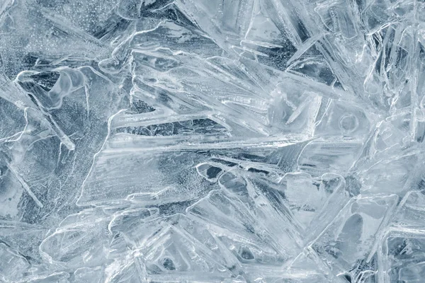 Ice background texture. Frozen water in various geometric abstract shapes. Seasonal natural effect. Cold weather. The surface of the winter water reservoir.