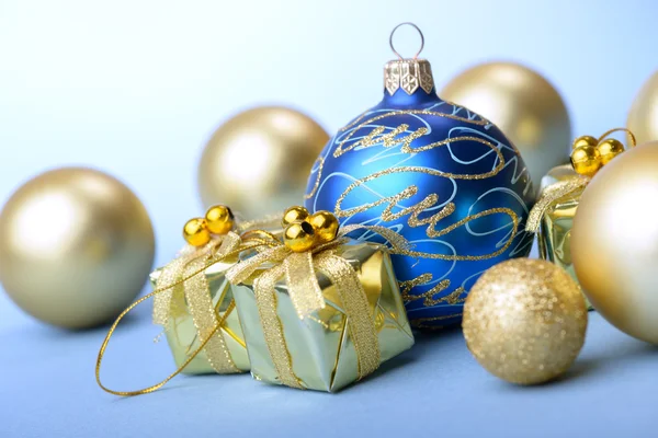 Mavi ve altın hediye kutusu mavi arka plan yeni yıl hediyesi ile Noel topları — Stok fotoğraf