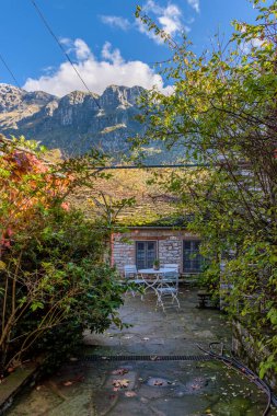 Yunanistan 'ın Zagori kentindeki papigo köyünde, sonbahar mevsiminde taştan binalar ve astraka arka planındaki geleneksel mimari manzarası