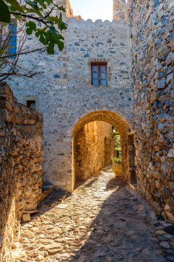 Monemvasia, Lakonia, Mora 'daki ortaçağ şatosundan geleneksel mimari ve sarı taş kemerinin görüntüsü.
