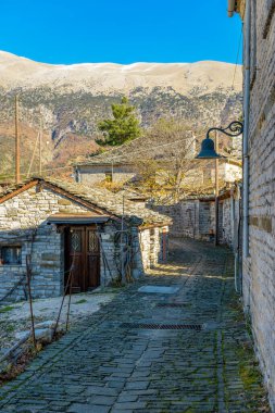 Epirus zagori Yunanistan 'ın pitoresk köyü Papigo' da sonbahar mevsiminde bir taş sokakta geleneksel mimarlık