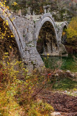 Kalogeriko (plakida), sonbahar mevsiminde Zagori, Epirus Yunanistan 'daki Voidomatis nehrinde yer alan eski kemer taşı köprüsü..