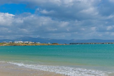 Sahili ön plan olarak görmek ve geleneksel drios köyünü de Paros Adası 'nda kış boyunca arka plan olarak görmek.