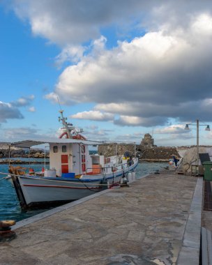 Yunanistan 'ın Naousa Paros limanında rüzgarlı bir günde demirlemiş geleneksel balıkçı tekneleriyle geleneksel Kiklad manzarası.