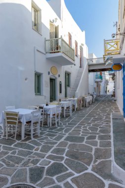 Yunanistan 'ın Naousa Paros adasındaki geleneksel bir tavernanın dış cephesi ve dar bir caddesi olan geleneksel Kiklad sokağı..