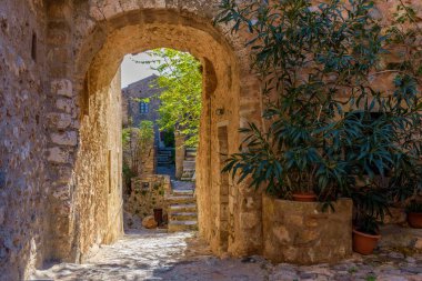 Monemvasia, Lakonia, Mora 'daki ortaçağ şatosundan geleneksel mimari ve sarı taş kemerinin görüntüsü.