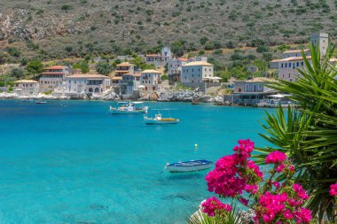 Limeni köyünde ünlü taş binalar çiçek açan bir bougainvillea ve Mani, Güney Moreloponnese, Yunanistan 'da turkuaz sular.