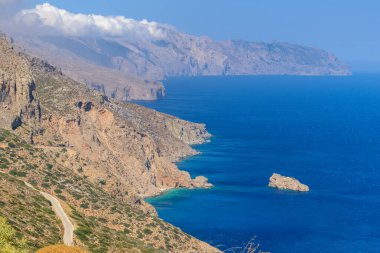 Agia Anna sahili üzerindeki dağların vahşi manzarası Amorgos adasındaki Kiklad Yunanistan 'daki büyük mavi filmiyle iyi bilinir..