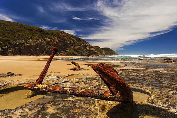 Ancla oxidada en las rocas en la orilla del mar — Foto de Stock