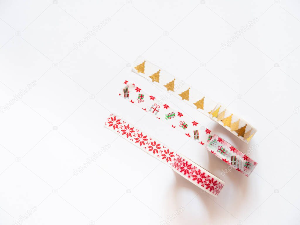 Close up of washi tape rolls isolated on white background. Christmas theme with xmas trees and gifts for decorating presents for the holidays. Copy space.