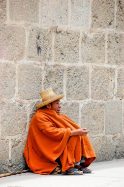 Cajamarca, Peru - Ekim 2019: Perulu bir adam turuncu pançolu bir şapkayla sokaklarda dileniyor. Evsizlerin ve yoksulluğun sosyal sorunu.