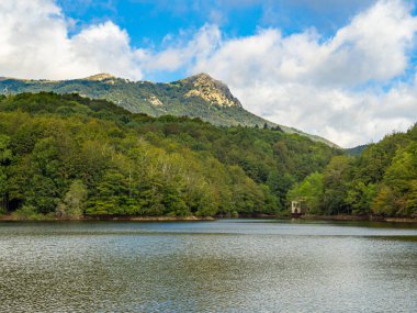 Santa Fe Reservoir 'da yaz günü, Montseny Doğal Parkı' nda (Katalonya, İspanya) mavi gökyüzü ile. Ağaçlar ve dağlarla dolu sakin bir bataklıktaki manzara. Vahşi doğa ve açık hava aktivite kavramı.