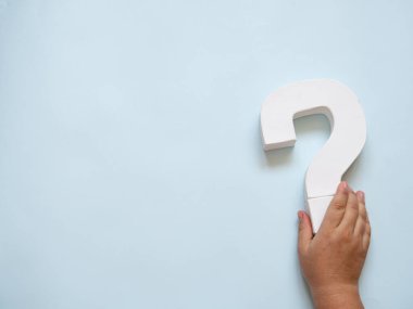 Kafkas eli olan bir soru işareti nesnesi onu kopyalama alanı ile mavi arka planda tutuyor. SSS ve fikir konsepti. Sorgulama sembolü beyaz