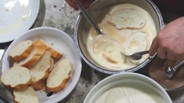 一个女人正在为圣周准备一种典型的西班牙菜 法国吐司 把面包浸在牛奶和鸡蛋里 用肉桂和糖煎 自制的烹调 — 图库视频影像
