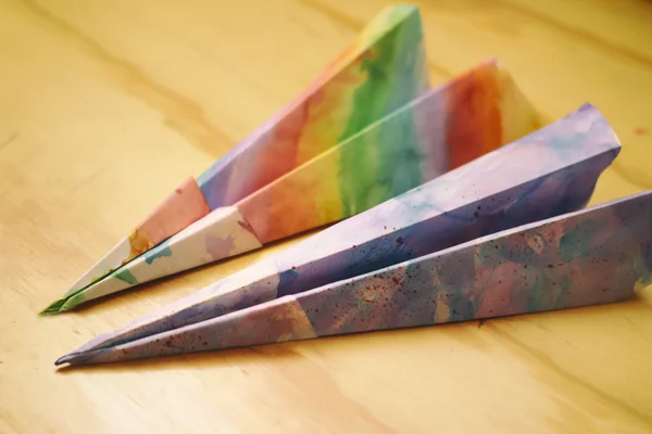 Paper colorful planes on a wood table — Stock Photo, Image