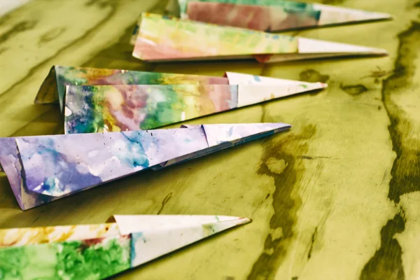 De kleurrijke vliegtuigen papier op een houten tafel — Stockfoto