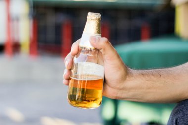 bira şişesi tutan el