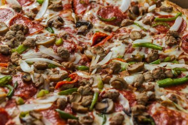 Biberli, mantarlı, biberli ve soğanlı pizza.