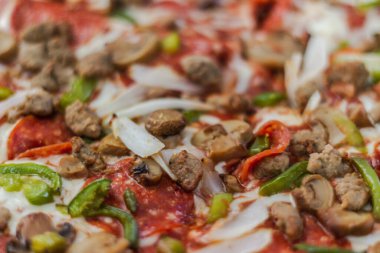 Biberli, mantarlı, biberli ve soğanlı pizza.