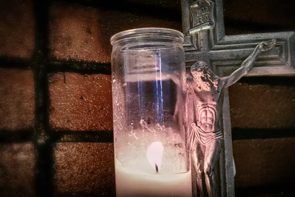 Crucifix  near lighting candle — Stock Photo, Image