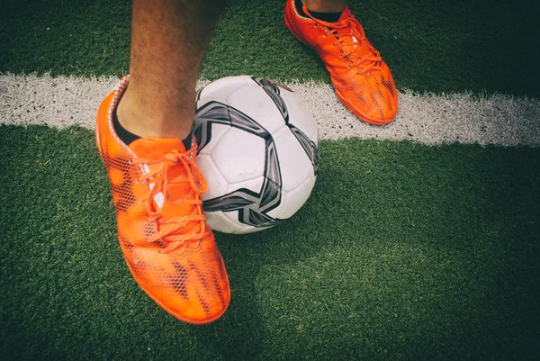 Fotboll och fötterna på gräs — Stockfoto