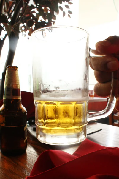 Korsó sör a kezében — Stock Fotó