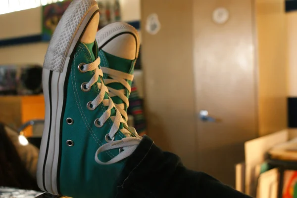 Feet in sneakers on table — Stock Photo, Image