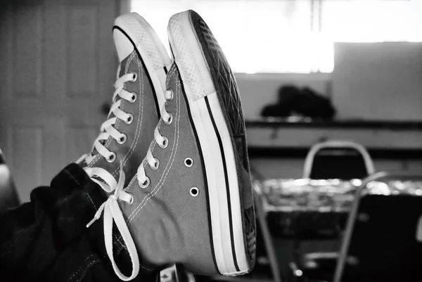 Fötter i sneakers på bord — Stockfoto