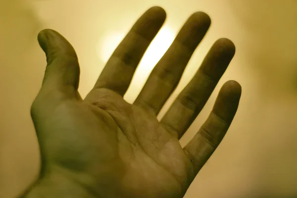 Menselijke hand tegen een lichte achtergrond van blured — Stockfoto