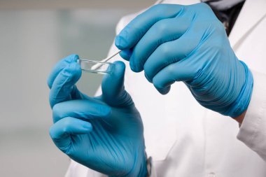 Bir tıp laboratuarında Coronavirus smear testi yapan doktorların ellerini kapatın. 