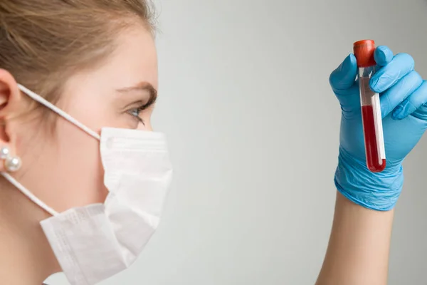 Tıbbi Eldivenleri Maskesiyle Genç Bir Kadın Bir Kan Sondasıyla Ilgileniyor — Stok fotoğraf