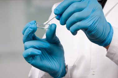 Bir tıp laboratuarında Coronavirus teşhisi için yapılan karalama testini yapan doktorların ellerini kapatın.