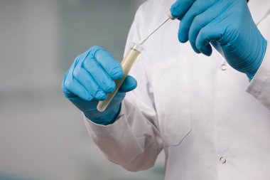 Bir tıp laboratuarında Coronavirus teşhisi için yapılan karalama testini yapan doktorların ellerini kapatın.