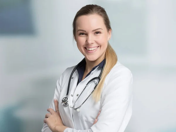 Portrait of a female likable family doctor in doctor's overall with stethoscope