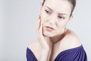 Genç bir kadın üzgün görünüyor ve duygusal ifadeler sergiliyor.