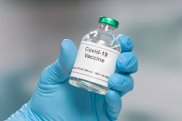 手戴蓝色手套 装有Covid 19疫苗的瓶子 — 图库照片