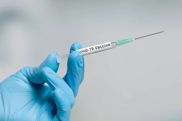 用装有Covid 19血清 疫苗的注射器将科学家或医生的手放在医用手套中 — 图库照片