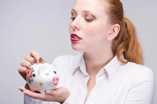 Junge Rothaarige Frau Steckt Eine Münze Ihr Sparschwein Porzellanbank — Stockfoto