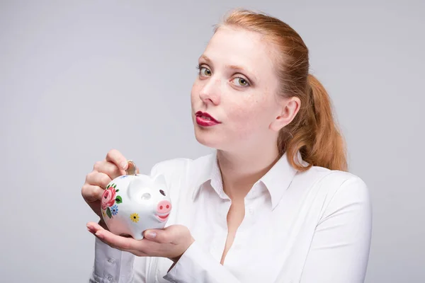 Junge Rothaarige Frau Steckt Eine Münze Ihr Sparschwein Porzellanbank — Stockfoto