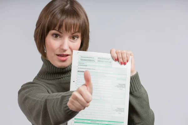 woman with a tax form makes shows thumbs up