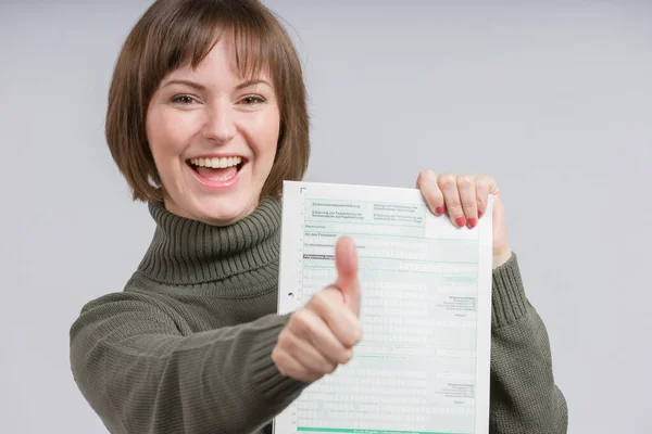 happy woman with a tax form makes shows thumbs up