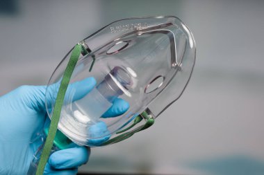 Solunum desteği için tek kullanımlık oksijen maskeli doktor eli.