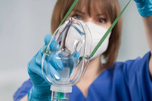 close up of nurse applying disposable oxygen mask for breathing support from patient view