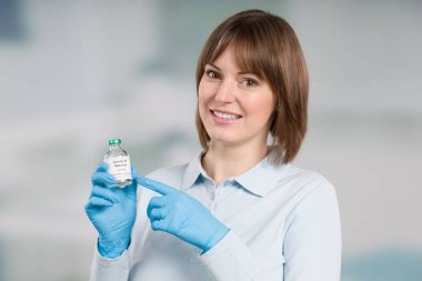 Kadın doktor ya da hemşire elinde Coronavirus / covid aşı şişesiyle