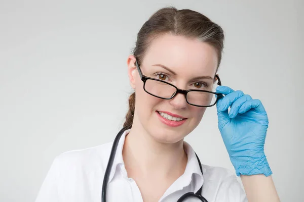 戴医用手套的女医生或女护士正在检查她的眼镜 — 图库照片