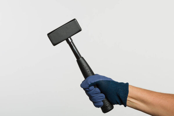 Hand in protective glove with a hammer 