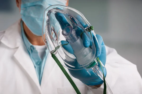 Solunum desteği için tek kullanımlık oksijen maskesiyle doktorun elini yakın plan çek. 