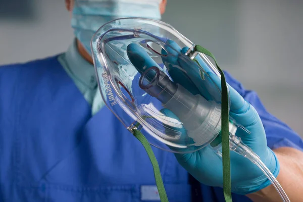 close-up of doctor\'s hand with disposable oxygen mask for breathing support