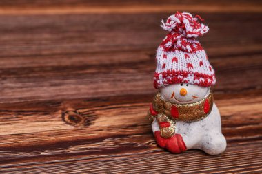 Kahverengi ahşap arka planda kardan adam