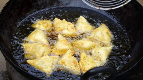 サモサは大きな黒いカダイや油でフライパンで揚げています 黒門外漢で揚げるインド料理の名店 — ストック写真